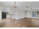 Open-concept living space flows into the kitchen with modern lighting and wood flooring at 9744 Rainelle Ln, Port Richey, FL 34668