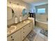 Bright bathroom featuring a double vanity, soaking tub, tiled floors, and updated fixtures at 9808 Riverchase Dr, New Port Richey, FL 34655