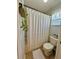 Cozy bathroom featuring bathtub with a white shower curtain, neutral color palette, and tile flooring at 9808 Riverchase Dr, New Port Richey, FL 34655