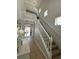 Open entryway featuring tiled floor, white console, and staircase with white railing leading to a loft area at 9808 Riverchase Dr, New Port Richey, FL 34655