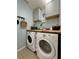 Functional laundry room with washer, dryer, and ample storage space at 9808 Riverchase Dr, New Port Richey, FL 34655