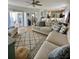 Open-concept living room with lots of natural light, tile floors, and comfortable, modern furniture at 9808 Riverchase Dr, New Port Richey, FL 34655