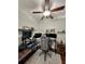Well-lit office with dark wood desk, gaming chair, monitors, and ceiling fan at 9808 Riverchase Dr, New Port Richey, FL 34655