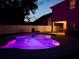 Night view of the backyard pool with vibrant purple lighting, perfect for evening swims and outdoor entertainment at 9808 Riverchase Dr, New Port Richey, FL 34655