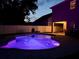 Night view of the backyard pool with vibrant purple lighting, perfect for evening swims and outdoor entertainment at 9808 Riverchase Dr, New Port Richey, FL 34655