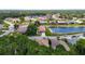 Scenic aerial view showcasing a tranquil community with a pond and beautifully landscaped yards surrounding well-kept homes at 10181 Holly Berry Dr, Weeki Wachee, FL 34613