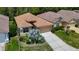 Aerial of a tan single-Gathering home with a well-maintained lawn and an attached two-car garage at 10181 Holly Berry Dr, Weeki Wachee, FL 34613