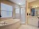 Bright bathroom featuring a soaking tub under a window and a glass-enclosed shower at 10181 Holly Berry Dr, Weeki Wachee, FL 34613