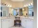 Bright bathroom vanity area with white cabinetry, dual sinks, and a makeup vanity at 10181 Holly Berry Dr, Weeki Wachee, FL 34613