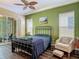 Bedroom boasting natural light from large windows, a stylish ceiling fan, and a comfortable seating area at 10181 Holly Berry Dr, Weeki Wachee, FL 34613