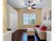 Cozy bedroom featuring dark hardwood flooring, neutral walls, double closet, and a comfortable sofa and ottoman at 10181 Holly Berry Dr, Weeki Wachee, FL 34613
