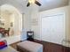 Cozy bedroom featuring dark hardwood flooring, neutral walls, double closet, and a comfortable sofa and ottoman at 10181 Holly Berry Dr, Weeki Wachee, FL 34613