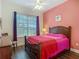 Bedroom showcases a large window, ceiling fan, and hardwood floors, providing a cozy and naturally lit space at 10181 Holly Berry Dr, Weeki Wachee, FL 34613