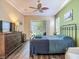 Spacious bedroom features a ceiling fan, large dresser, and a sliding glass door to the outdoors at 10181 Holly Berry Dr, Weeki Wachee, FL 34613