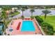 Aerial view of a large community pool with lounge chairs, palm trees, and views of a lake at 10181 Holly Berry Dr, Weeki Wachee, FL 34613