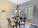 Bright dining area featuring a glass table, metal chairs, and large windows with blinds at 10181 Holly Berry Dr, Weeki Wachee, FL 34613