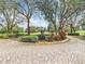 Beautiful community entrance with a statue surrounded by colorful plants and an expansive brick driveway at 10181 Holly Berry Dr, Weeki Wachee, FL 34613