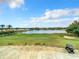 Scenic view of the community golf course, showcasing lush greenery and a tranquil lake under a beautiful, partly cloudy sky at 10181 Holly Berry Dr, Weeki Wachee, FL 34613