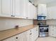 Bright kitchen with white cabinets, stainless steel oven and microwave, and neutral backsplash at 10181 Holly Berry Dr, Weeki Wachee, FL 34613