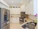 Modern kitchen with stainless steel appliances, white cabinets, and neutral countertops at 10181 Holly Berry Dr, Weeki Wachee, FL 34613