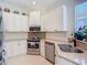 Bright kitchen featuring stainless steel appliances and white cabinets with black hardware at 10181 Holly Berry Dr, Weeki Wachee, FL 34613