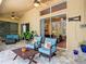 Covered lanai with comfortable seating, ceiling fans, stone flooring, and garden views at 10181 Holly Berry Dr, Weeki Wachee, FL 34613