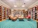Comfortable library area with bookshelves, leather seating, and a green patterned rug at 10181 Holly Berry Dr, Weeki Wachee, FL 34613