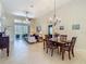 Elegant living room featuring tile floors, tall ceilings, slider to lanai, and an adjacent dining area at 10181 Holly Berry Dr, Weeki Wachee, FL 34613