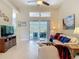 Bright living room featuring high ceilings and sliding glass doors leading to a screened patio at 10181 Holly Berry Dr, Weeki Wachee, FL 34613
