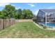 View of the spacious backyard and screened-in pool, surrounded by a privacy fence at 10267 Elgin Blvd, Spring Hill, FL 34608