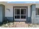 Close up of the front entrance with a screen door and brick walkway leading to the home at 10267 Elgin Blvd, Spring Hill, FL 34608