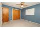 Bright bedroom featuring soft carpet, natural light, ceiling fan, and double closet at 10386 Myra St, Spring Hill, FL 34608