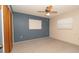 Comfortable bedroom featuring plush carpeting, a ceiling fan, and plenty of natural light from the windows at 10386 Myra St, Spring Hill, FL 34608