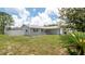 Well-manicured lawn surrounds this cozy home, with mature landscaping and a fenced yard at 10386 Myra St, Spring Hill, FL 34608