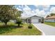 Charming single-story home featuring a well-maintained lawn, mature tree, and a spacious driveway leading to an attached garage at 10386 Myra St, Spring Hill, FL 34608