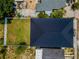 Bird's eye view of the property, showing the dark roof, fenced yard, and surrounding landscape details at 111 E Cedar St, Tarpon Springs, FL 34689