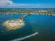 A scenic aerial view showcases a beach connected by a narrow road, surrounded by blue waters and lush greenery at 111 E Cedar St, Tarpon Springs, FL 34689