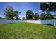 View of the large backyard area featuring a white vinyl fence and lush green lawn at 111 E Cedar St, Tarpon Springs, FL 34689