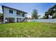 Backyard featuring an expansive green lawn and white vinyl fence for privacy and a home on stilts at 111 E Cedar St, Tarpon Springs, FL 34689