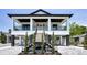 Stunning two-story home featuring a charming front porch, black railings, and well-maintained landscaping at 111 E Cedar St, Tarpon Springs, FL 34689