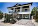 Charming two-story home with a covered porch, black railings, and convenient ground floor parking at 111 E Cedar St, Tarpon Springs, FL 34689