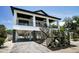 Lovely two-story home offering a covered porch, black railings, and convenient ground-level parking at 111 E Cedar St, Tarpon Springs, FL 34689