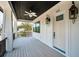 Charming porch boasts a dark ceiling, a ceiling fan, and an entrance door with blue trim detail at 111 E Cedar St, Tarpon Springs, FL 34689
