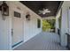 Elegant porch features a dark ceiling, a ceiling fan, a lantern, and a view to the neighborhood at 111 E Cedar St, Tarpon Springs, FL 34689
