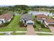 A stunning aerial view of a single-story home with a gray roof, nestled beside a serene lake and lush greenery at 11398 Juglans Dr, Odessa, FL 33556