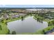 Panoramic aerial view of a serene community, showcasing a picturesque lake and surrounding homes at 11398 Juglans Dr, Odessa, FL 33556