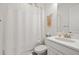 Clean bathroom featuring a white vanity, toilet, shower with curtain, and decorative wall hanging at 11398 Juglans Dr, Odessa, FL 33556