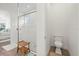 Bright bathroom with glass shower, wooden stool, and separate toilet room at 11398 Juglans Dr, Odessa, FL 33556