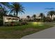 Esplanade entrance at dusk featuring a community sign with colorful landscaping and palm trees at 11398 Juglans Dr, Odessa, FL 33556