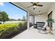 Relaxing screened lanai with view of lake, offering cozy seating and ceiling fans at 11398 Juglans Dr, Odessa, FL 33556